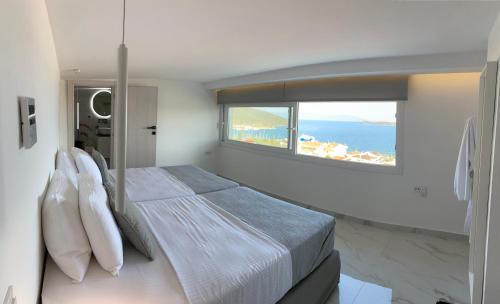 a bedroom with a large bed with a large window at DK Luxury Suite in Nea Peramos