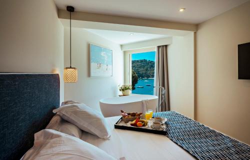 Una habitación de hotel con una bandeja de comida en una cama. en Aiguablava Luxury Apartments, en Begur