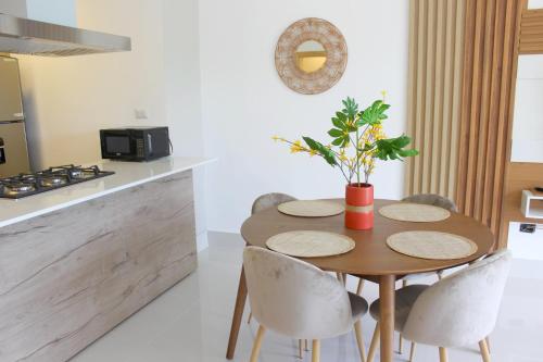 a kitchen with a wooden table with chairs and a table sidx sidx sidx at Amar'e Aparthotel & Spa in Las Terrenas