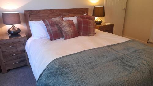 a bedroom with a large bed with pillows and two lamps at Otters Retreat in Big Sand