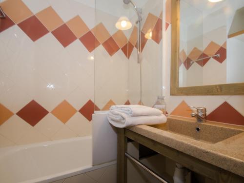 une salle de bain avec un lavabo, une baignoire et un miroir dans l'établissement Studio cosy à Chamonix proche du ski-bus - FR-1-343-238, à Chamonix-Mont-Blanc