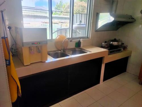 a kitchen with a sink and a counter top at Sibu kulas homestay in Sibu
