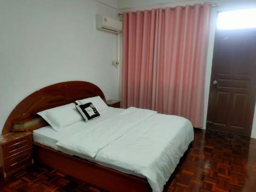 a bedroom with a bed and a pink curtain at Sibu kulas homestay in Sibu