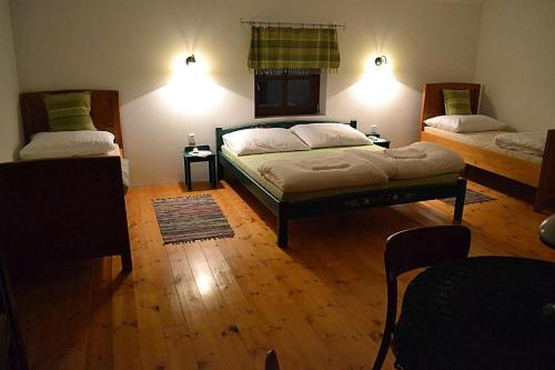 1 dormitorio con 2 camas y suelo de madera en Villa Filia, en Okoc - Velky Sek