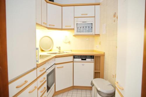 eine kleine Küche mit einem Waschbecken und einem WC in der Unterkunft Hanseat II App 148 in Grömitz