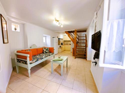 Giasemi traditional house في بوروس: غرفة معيشة مع أريكة وطاولة