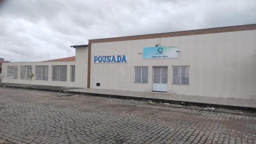 een wit gebouw met een bord aan de zijkant bij Pousada Parque das Águas in Tucano