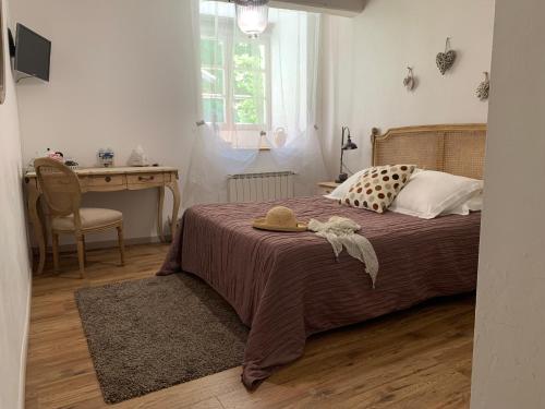 a bedroom with a bed with a table and a desk at Maison d'Hôtes du Domaine Fournié in Tarascon-sur-Ariège