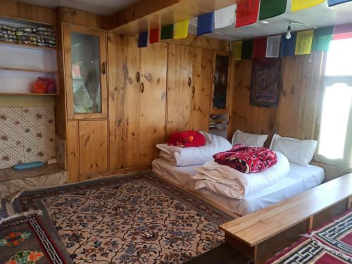 2 camas en una habitación con paredes de madera en Nizer khangchung Homestay, en Mani