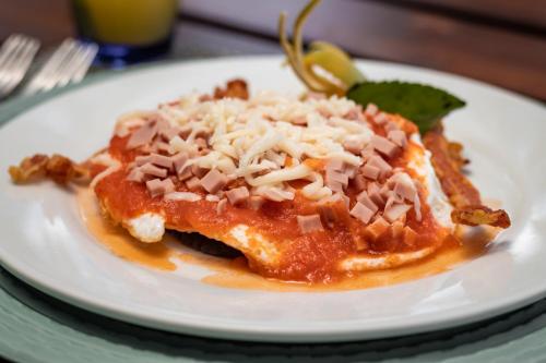 a white plate with food on a table at Grand Slam Fishing Lodge Tulum in Punta Allen