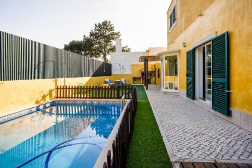 uma casa com piscina ao lado de um edifício em Beautiful Villa in Sunny Lagoa em Sesimbra