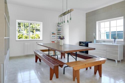 a kitchen with a table and benches in a room at Sunny Villa in Lagoa de Albufeira - private pool by Lisbeyond in Sesimbra
