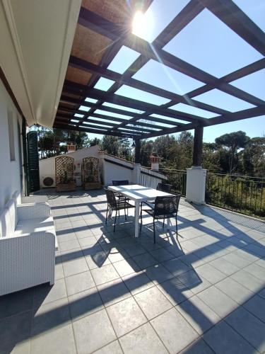 a patio with a table and chairs under a roof at Residenza Casa Bianca in Marina di Massa