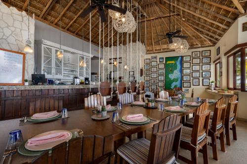a dining room with a long table and chairs at Grand Slam Fishing Lodge Tulum in Punta Allen