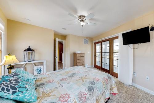 a bedroom with a bed and a flat screen tv at Town of Fenwick Island - 41 Bayside Dr in Fenwick Island