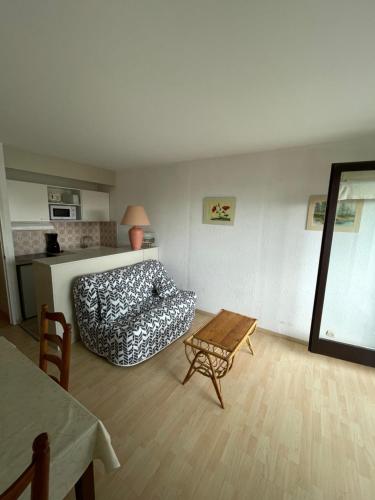 een woonkamer met een bed en een tafel bij Réf 543, Seignosse Océan, Appartement avec aperçu Mer, à 150m de la plage, 4 personnes in Seignosse