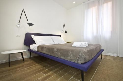 1 dormitorio con 1 cama azul, mesa y ventana en Corte Spagnola, en Verona
