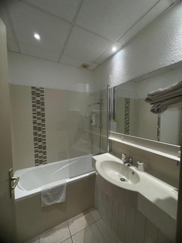 a bathroom with a sink and a tub and a mirror at Le Clos De L'aube Rouge - Montpellier / Castelnau le Lez in Castelnau-le-Lez