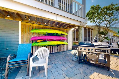 a patio with a bbq and kayaks and a grill at Town of Fenwick Island - 41 Bayside Dr in Fenwick Island