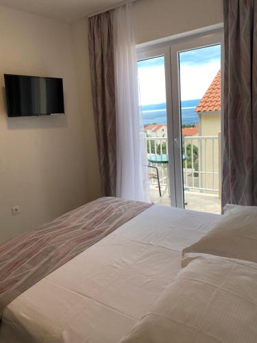 a bedroom with a bed and a view of the ocean at Eni apartments BOL in Bol