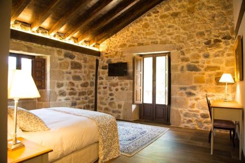 1 dormitorio con cama, escritorio y ventana en Casas Rurales La Cuplia, en Pedroso