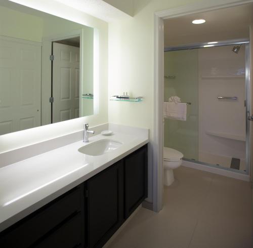 a bathroom with a sink and a toilet and a mirror at Residence Inn by Marriott Cleveland Beachwood in Beachwood