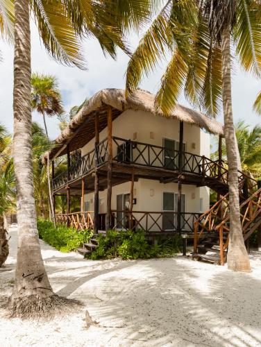 a resort on the beach with palm trees at Grand Slam Fishing Lodge Tulum in Punta Allen