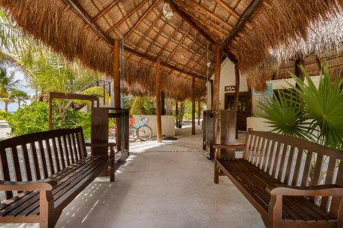 a pavilion with benches and a straw roof at Grand Slam Fishing Lodge Tulum in Punta Allen