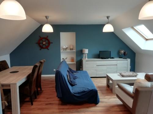 uma sala de estar com uma mesa e uma parede azul em Les gîtes du petit Marcel em Soudan