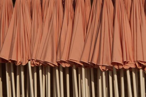 a group of red umbrellas on a wall at Cap d'Antibes Beach Hotel in Juan-les-Pins
