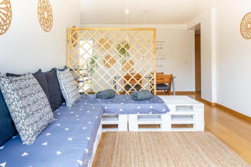 a living room with a blue couch with pillows at One Bedroom Apartment with Stunning River Views and Private Rooftop! in Lisbon