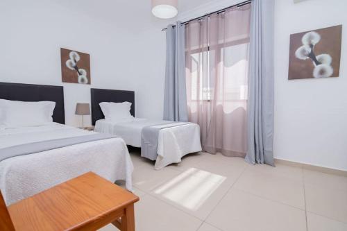 - une chambre blanche avec 2 lits et une fenêtre dans l'établissement Avo Vitoria by Innkeeper, à Guia