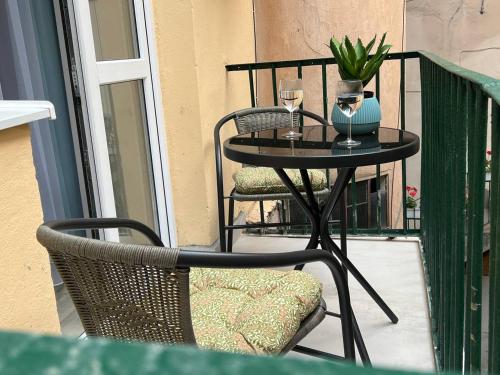 einen Tisch und Stühle auf einem Balkon mit Tisch und Weingläsern in der Unterkunft DeMar Apart Doroshenka in Lwiw
