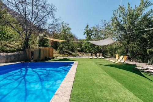 a backyard with a swimming pool and a lawn with chairs at Cabañas El Palomar in San Alfonso