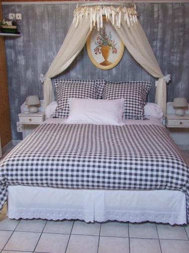 - un lit avec une couverture en damier noir et blanc dans l'établissement Gite les Orchidées, à Honfleur