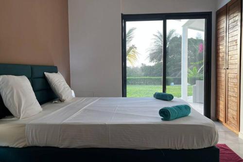 ein Schlafzimmer mit einem großen Bett und einem großen Fenster in der Unterkunft Maya Plage, Villa en bord de mer in Cap Skirring
