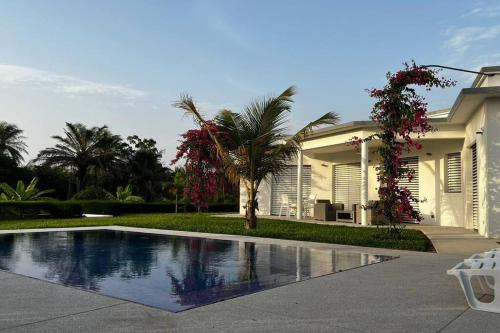uma casa com piscina em frente a uma casa em Maya Plage, Villa en bord de mer em Cap Skirring