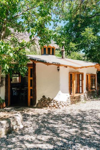 a small white house with a tree at Cabañas El Palomar in San Alfonso