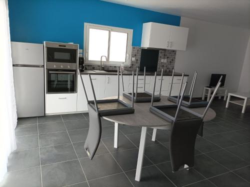 une cuisine avec une table et des chaises dans une cuisine dans l'établissement Maison récente Océadune à Saint-Jean de Monts, à Saint-Jean-de-Monts