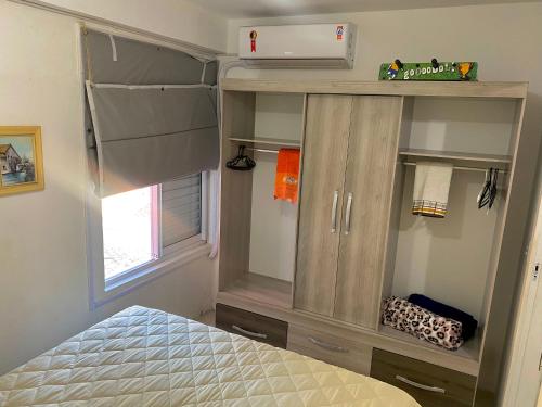 1 dormitorio con vestidor y 1 cama en una habitación en Apartamento Floripa 16 - Próximo Ao Centro, UFSC, Aeroporto e Praias, en Florianópolis