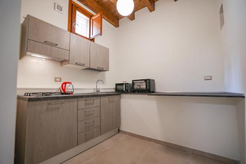 a kitchen with wooden cabinets and a counter top at Case Ruggieri Luxury apt - Don Pietro in Gratteri