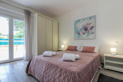 a bedroom with a large bed with two pillows on it at Wonderful villa wit pool surrounded by nature, high level of privacy a few minutes by the beach and town center by car in Valtura