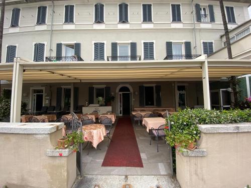 a building with tables and chairs in front of it at Hotel Due Palme in Mergozzo