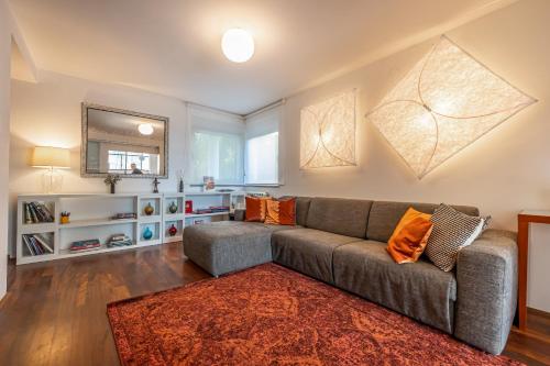 ein Wohnzimmer mit einem grauen Sofa und einem roten Teppich in der Unterkunft Villa CD in Dramalj