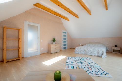 een slaapkamer met een bed en een houten vloer bij Jaukus svečių namelis in Druskininkai