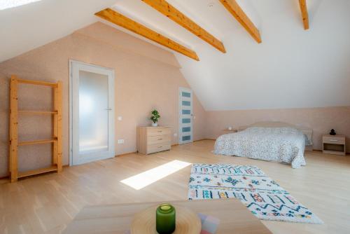 Un dormitorio con una cama y suelo de madera. en Jaukus svečių namelis, en Druskininkai