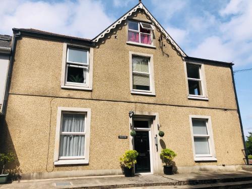 a brick house with white windows and a door at Nyth Bach - Little Nest in Pembroke Dock