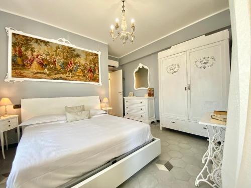 ジェノヴァにあるCasaViva - Le Vele di Angelaの白いベッドと壁に絵画が飾られたベッドルーム1室
