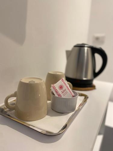 a tray with two coffee cups and a tea pot at VIESTEROOMS in Vieste