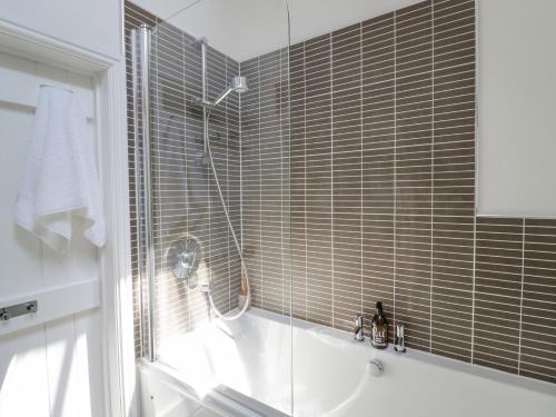 a bathroom with a shower and a tub and a sink at The Chicken Shed in Warwick